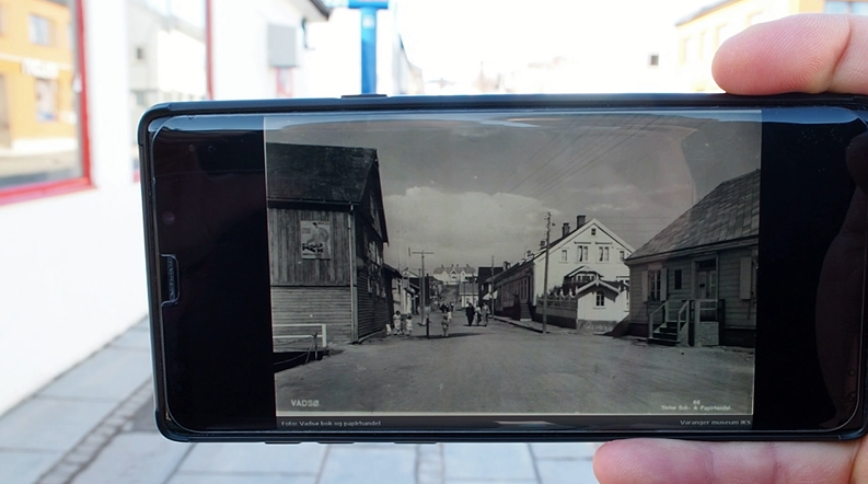 Mobiltelefon som viser et svart-hvittbilde av tollbugata i vadsø før krigen. Foto.